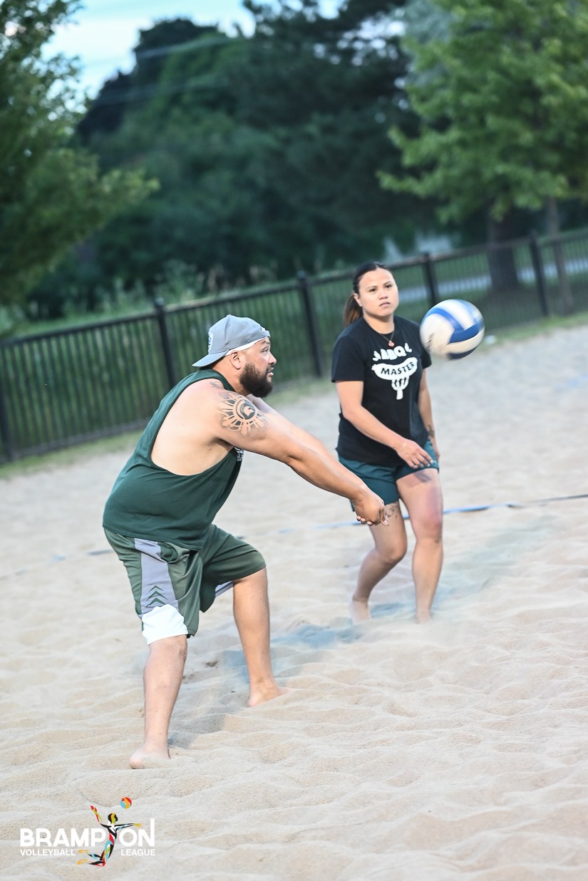 A player passes a volleyball on an outdoor sand court.